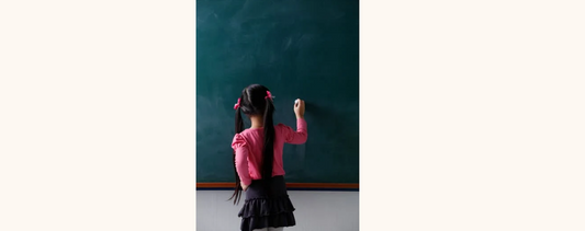 "A girl writing on a black board vertically."