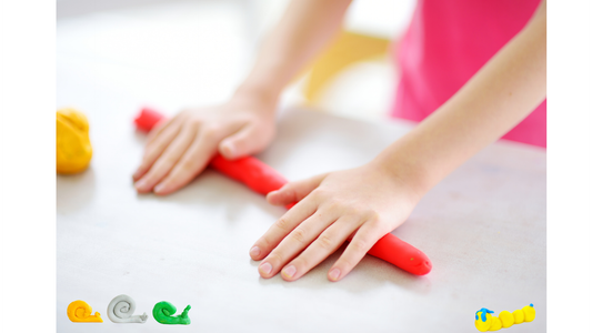 A young girl rolling play dough. 