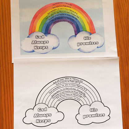 A printed rainbow-themed scripture poster and colouring page laid on a wooden surface, showing a colourful rainbow with clouds reading 'God Always Keeps' and 'His promises,' plus a black-and-white version. 