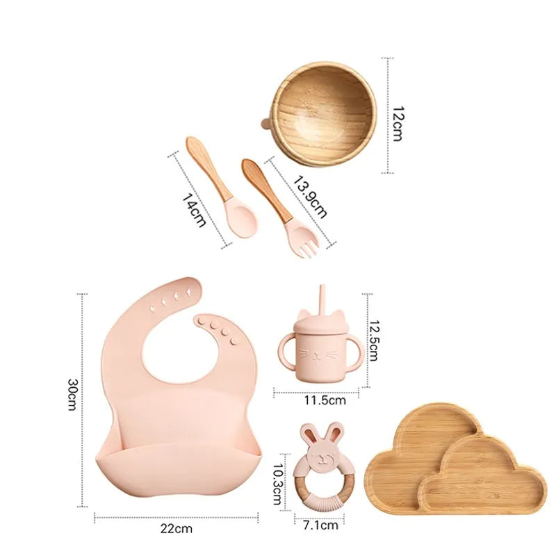 "A pink and bamboo bib, rattle, cup, spoon, fork, bowl, cloud shaped plate for babies and toddlers." 