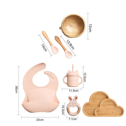 "A pink and bamboo bib, rattle, cup, spoon, fork, bowl, cloud shaped plate for babies and toddlers." 