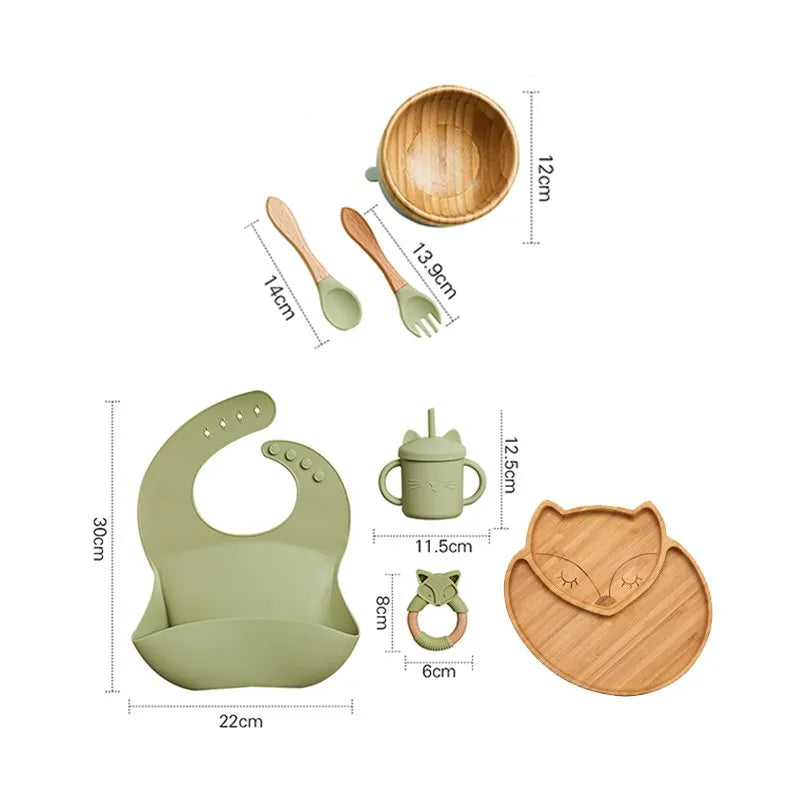 "A green and bamboo bib, rattle, cup, spoon, fork, bowl, cat shaped plate for babies and toddlers." 