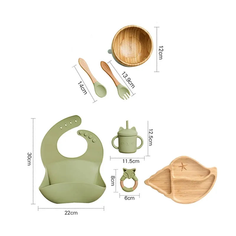 "A green and bamboo bib, rattle, cup, spoon, fork, bowl, shell shaped plate for babies and toddlers." 