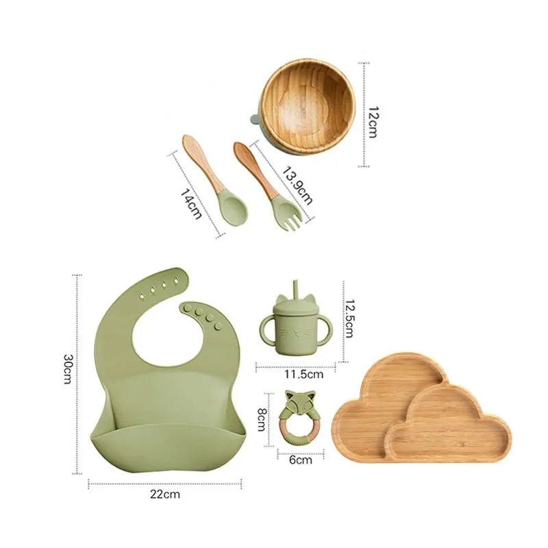 "A green and bamboo bib, rattle, cup, spoon, fork, bowl, cloud shaped plate for babies and toddlers ."