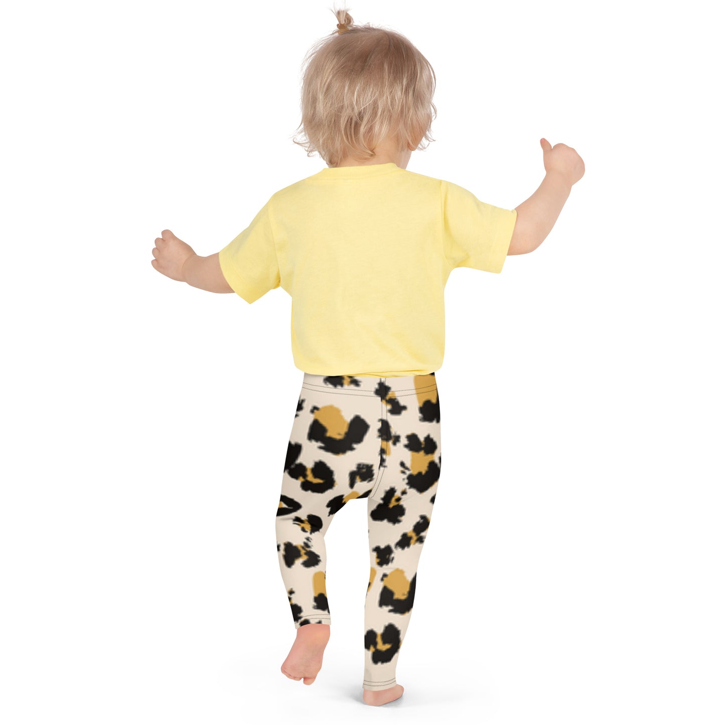 "The back of a toddler girl wearing a yellow shirt and animal print leggings."