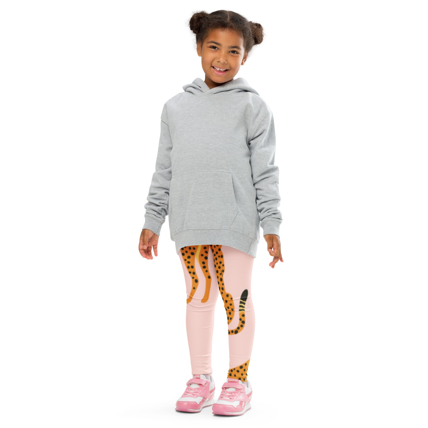 "A young girl in a grey hoodie wearing pink cheetah leggings."