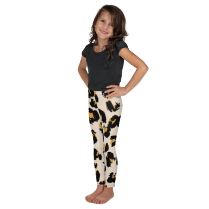 "A little girl posing in a black shirt and animal print leggings."