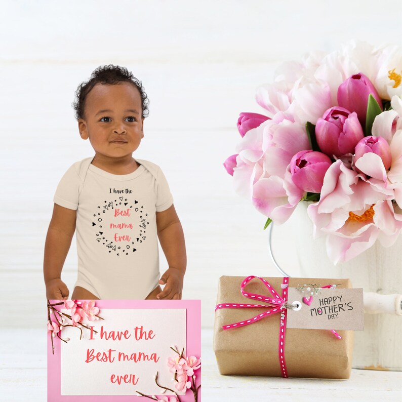 "A boy toddler wearing a neutral colour best mama ever bodysuit." 