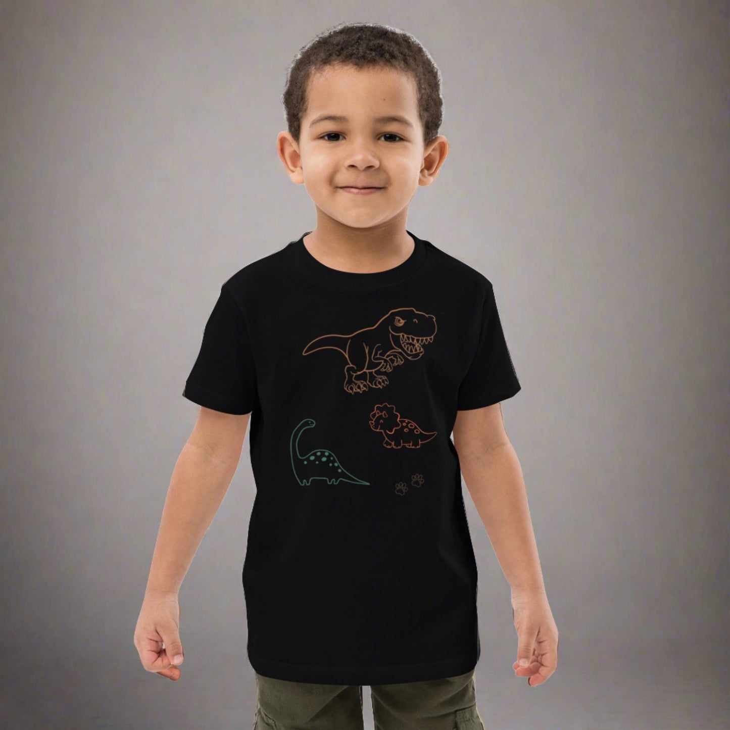 "A boy wearing a black dinosaur t-shirt."