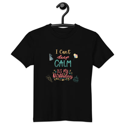 "A Kids Black Unisex T-Shirt with Keep Calm It's My Birthday Slogan on a hanger."