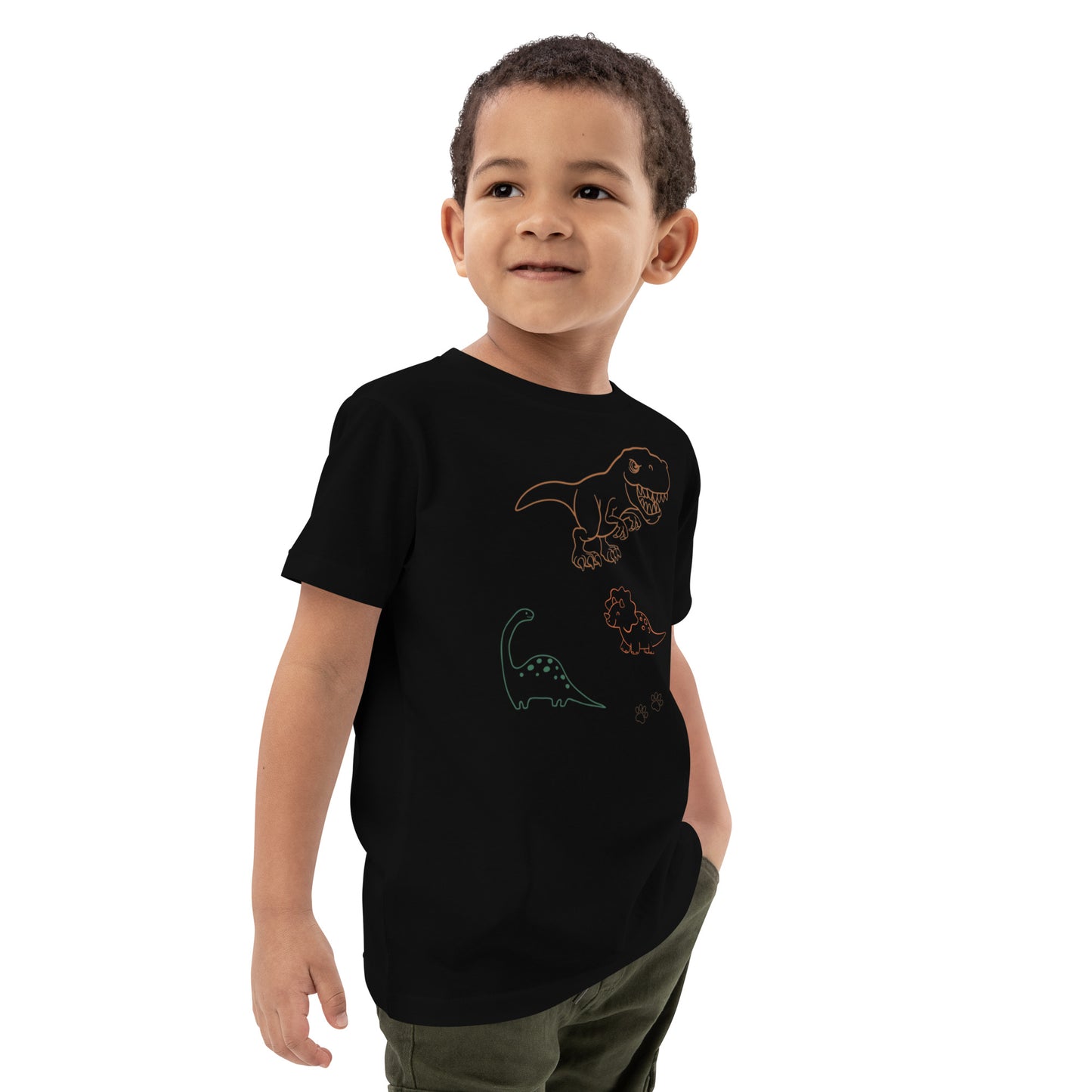 "A boy wearing a black dinosaur shirt posing with his hand in his pocket."